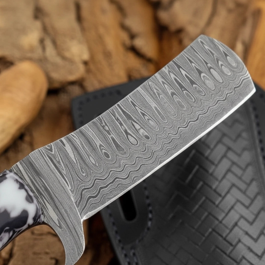 A close-up view of the Damascus steel blade of an 8-inch handmade calf cutter knife, focusing on the intricate, wavy pattern of the steel.