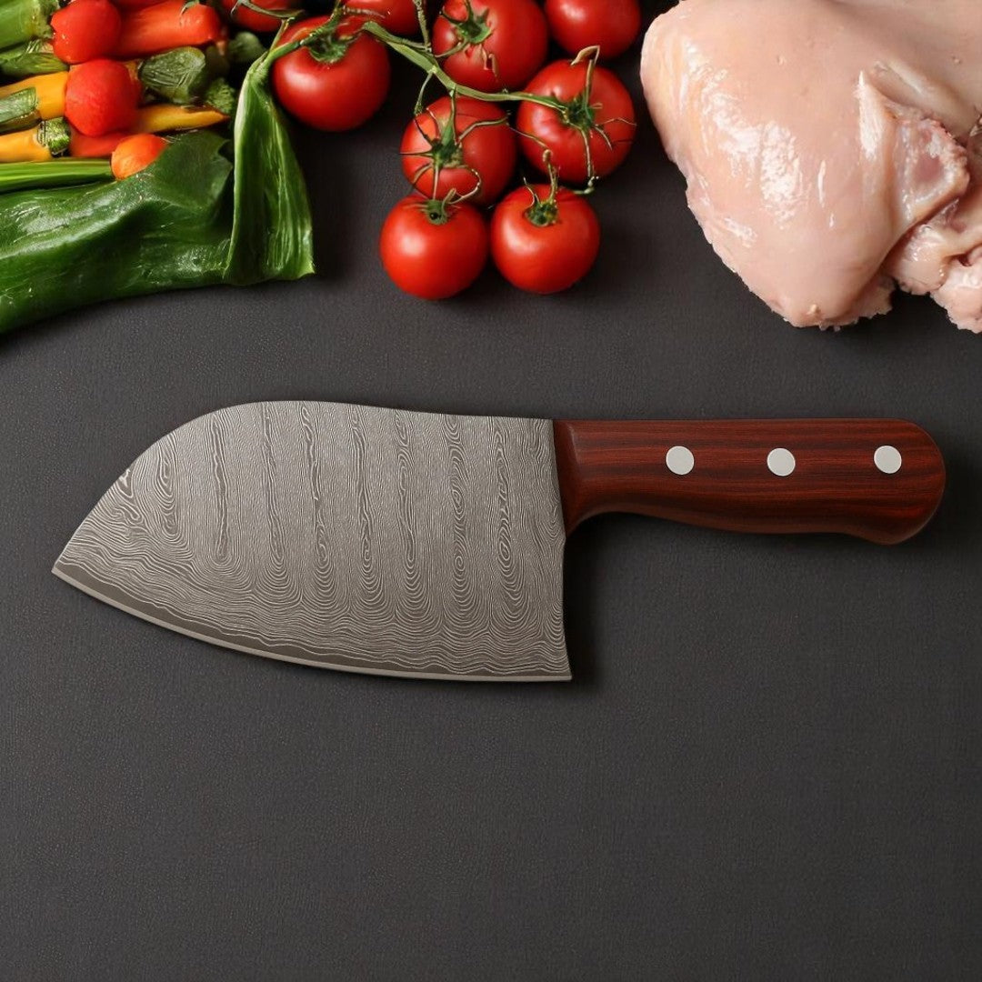 Classic Damascus Serbian Chef Knife with wavy pattern blade and wood handle, resting on a dark surface with fresh vegetables and raw chicken