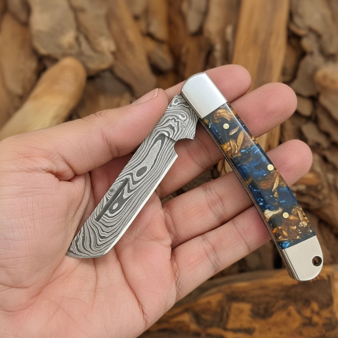 Hand holding a Bull Cutter pocket knife with a decorative handle against a wooden background