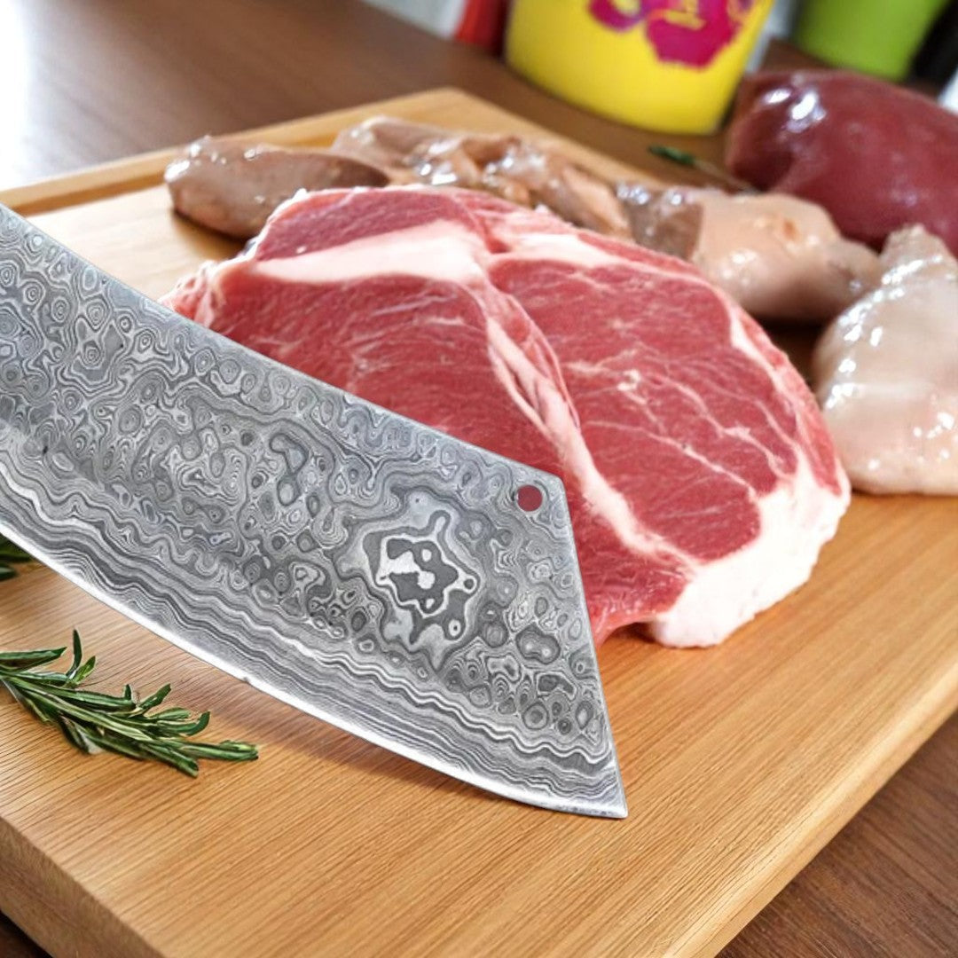 Damascus Butcher Cleaver Knife with Micarta handle and patterned blade, resting on raw meat cuts on a black surface.
