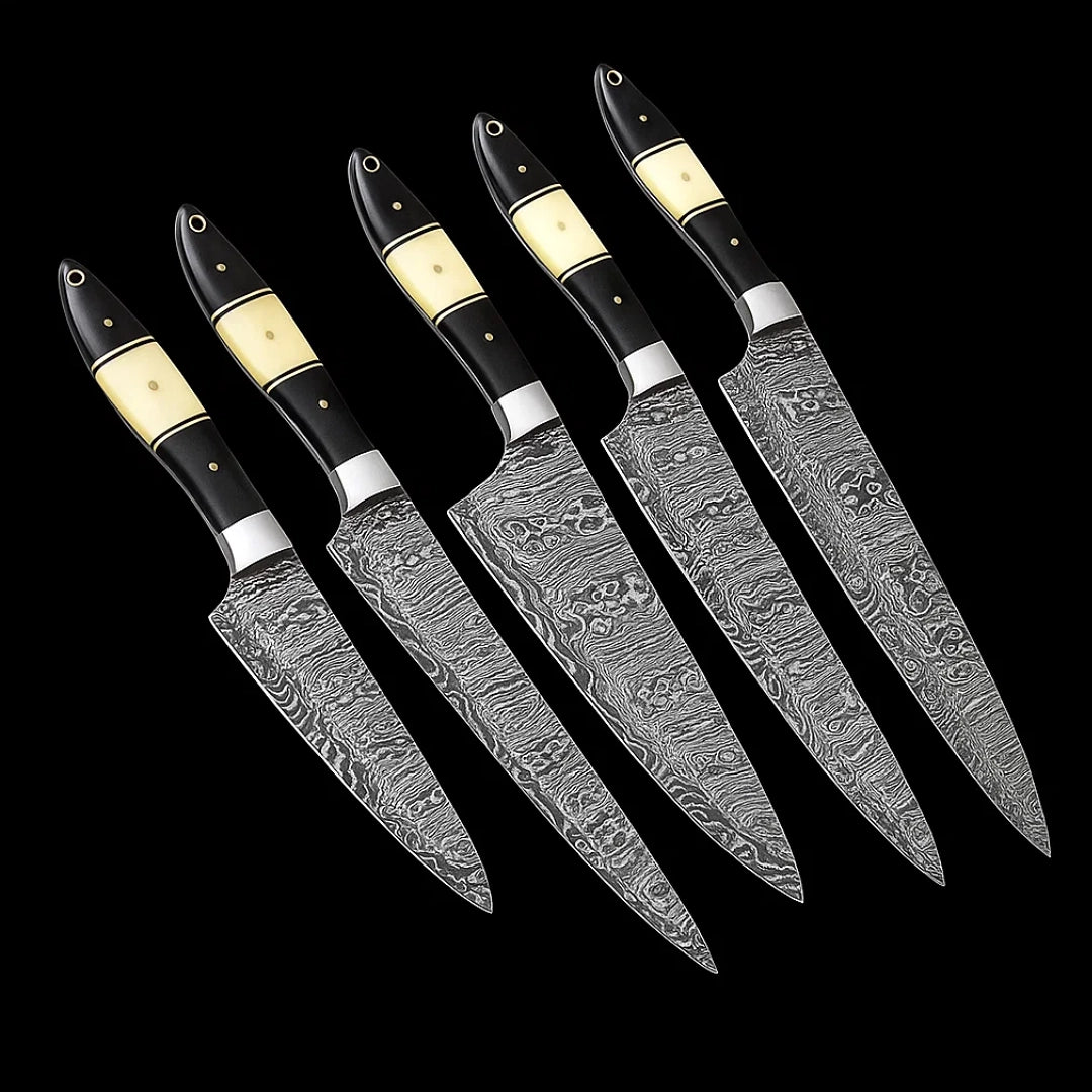 Set of five Damascus steel kitchen knives with black handles on a black background