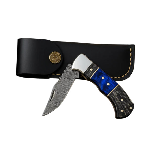 Damascus pocket knife with a sleek, black leather sheath. The knife features a layered Damascus steel blade with a beautifully patterned design and a multi-colored handle with black, blue, and silver accents. The handle includes smooth wooden and resin inlays with brass rivets, adding to its elegant appearance.