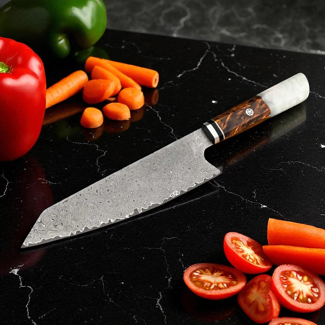 Chef's knife with a decorative handle on a black marble surface surrounded by vegetables.