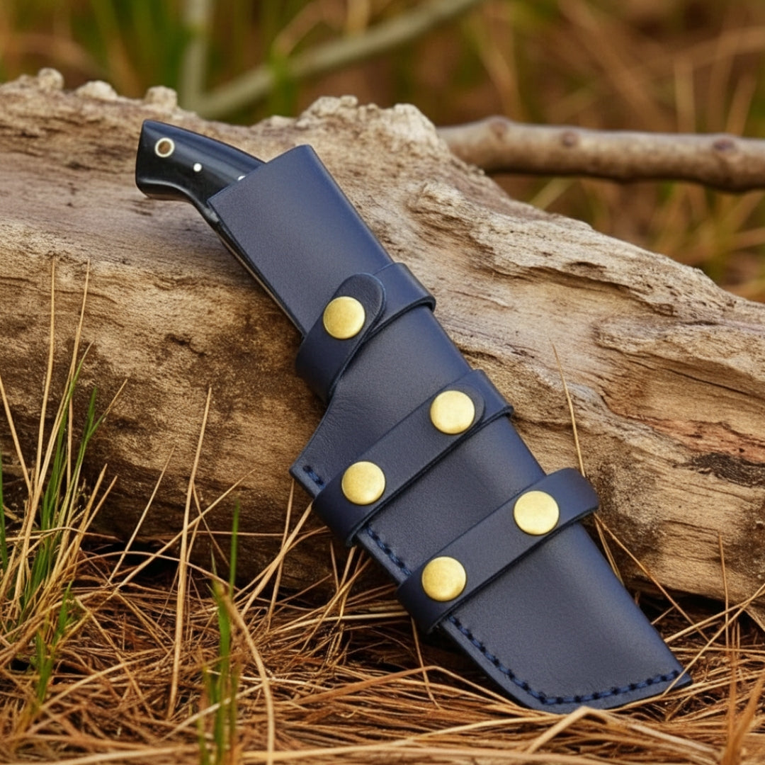 Blue leather knife sheath with brass fasteners on a wooden log