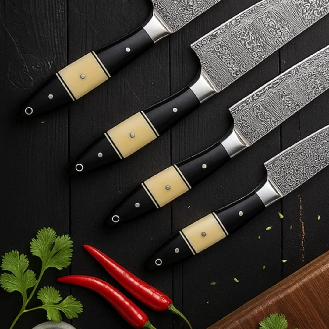 Set of knives with decorative handles on a dark surface with herbs and peppers.