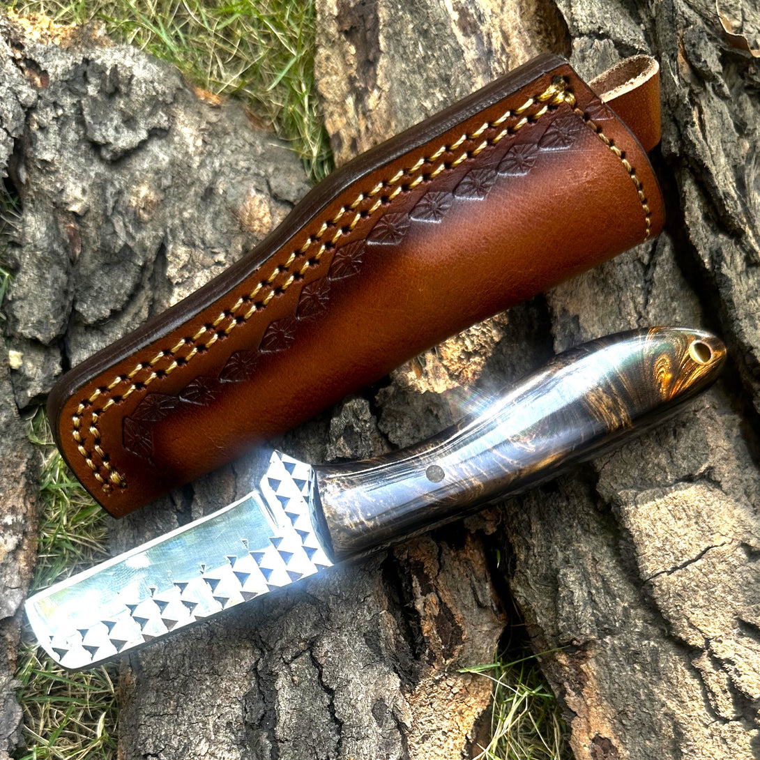 Cowboy Bull Cutter Knife with a brown leather sheath on a wooden surface
