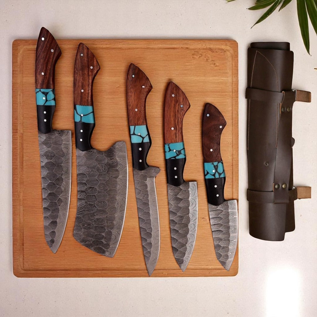 Set of knives with wooden handles and turquoise accents on a wooden cutting board, next to a leather knife sheath.
