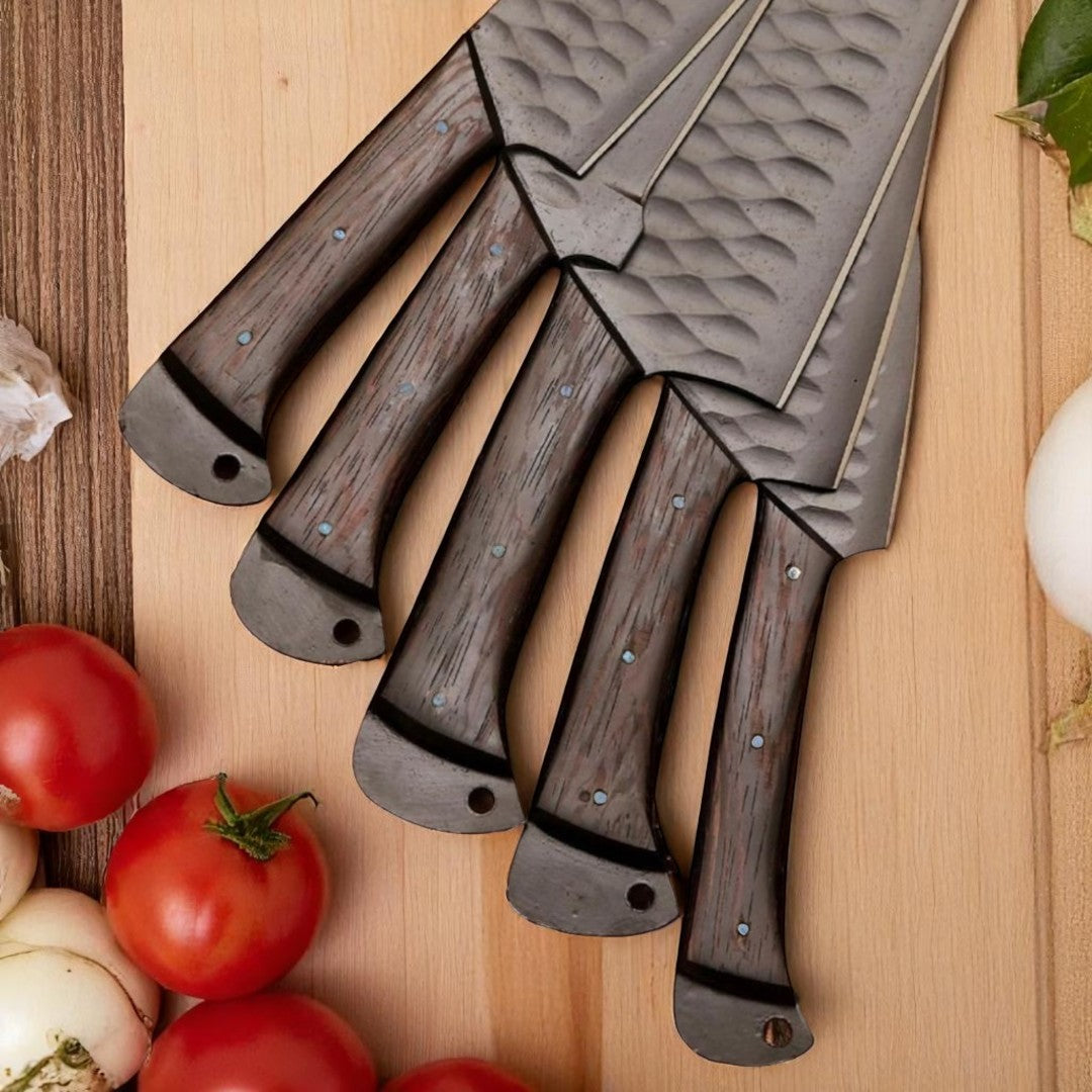 Five black hammered kitchen knives with dark wood handles, displayed upright next to their dark brown leather roll bag on a white background

