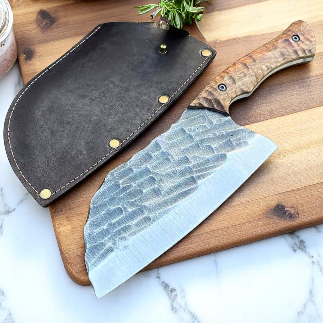 Bone Splitter Serbian Cleaver Knife with textured blade and walnut wood handle, displayed with its dark brown leather case on a white background.