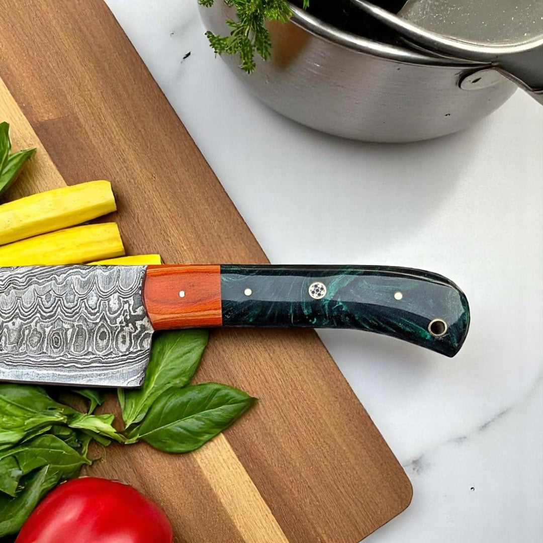 Close-up detail of the ergonomic green and black swirled resin and wood handle of a Damascus Chef Knife, showing its unique design