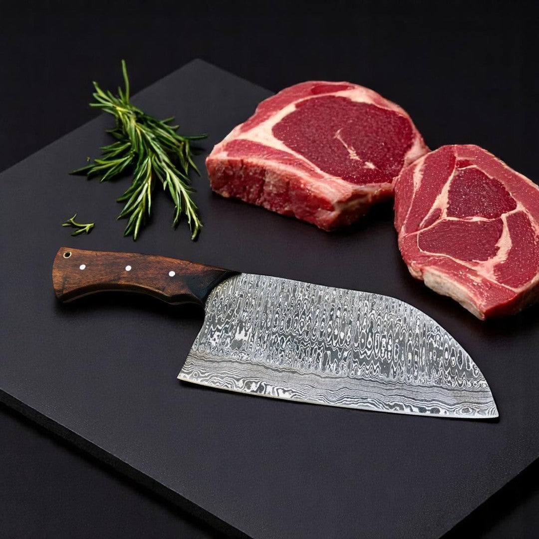 Close-up view of the Damascus steel blade pattern of The Butcher's Cleaver Bone Chopper, showing its intricate "Raindrop" design near raw meat