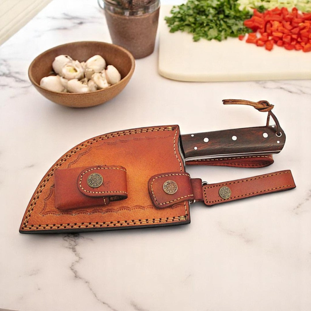 Classic Damascus Serbian Almazan Cleaver Knife with wood handle and wavy pattern blade, displayed upright next to its brown leather sheath on a white background

