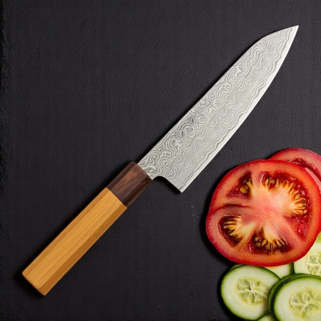 Japanese Damascus Santoku Knife with Wa-Handle on a dark surface next to sliced tomato and cucumber


